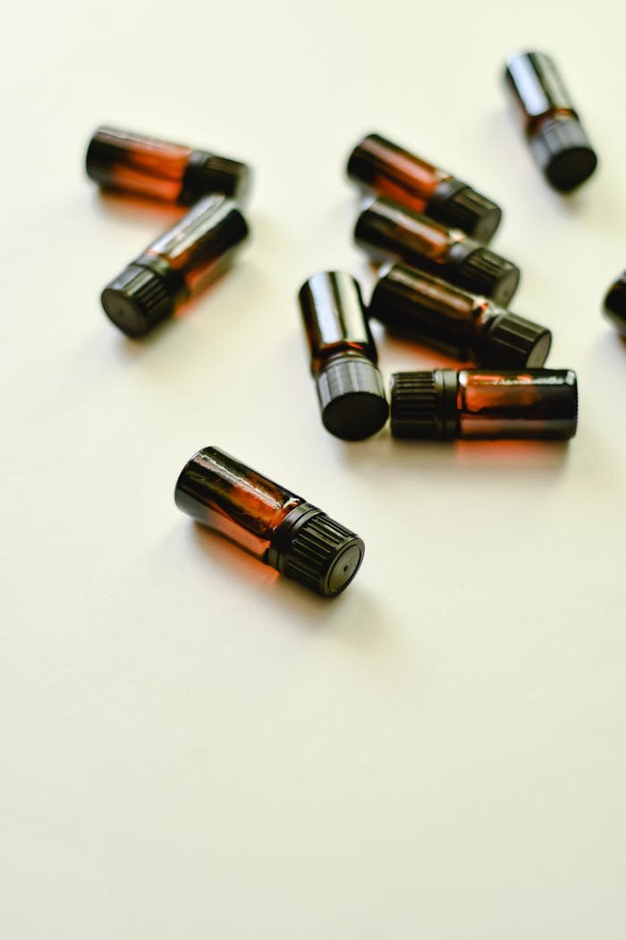 Array of small essential oil bottles scattered on a white surface.