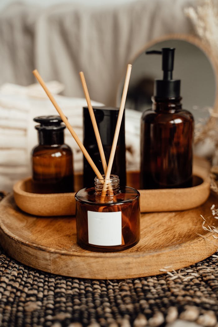 Elegant arrangement of aromatic reed diffuser and bottle on wooden tray, perfect for relaxation and decor.