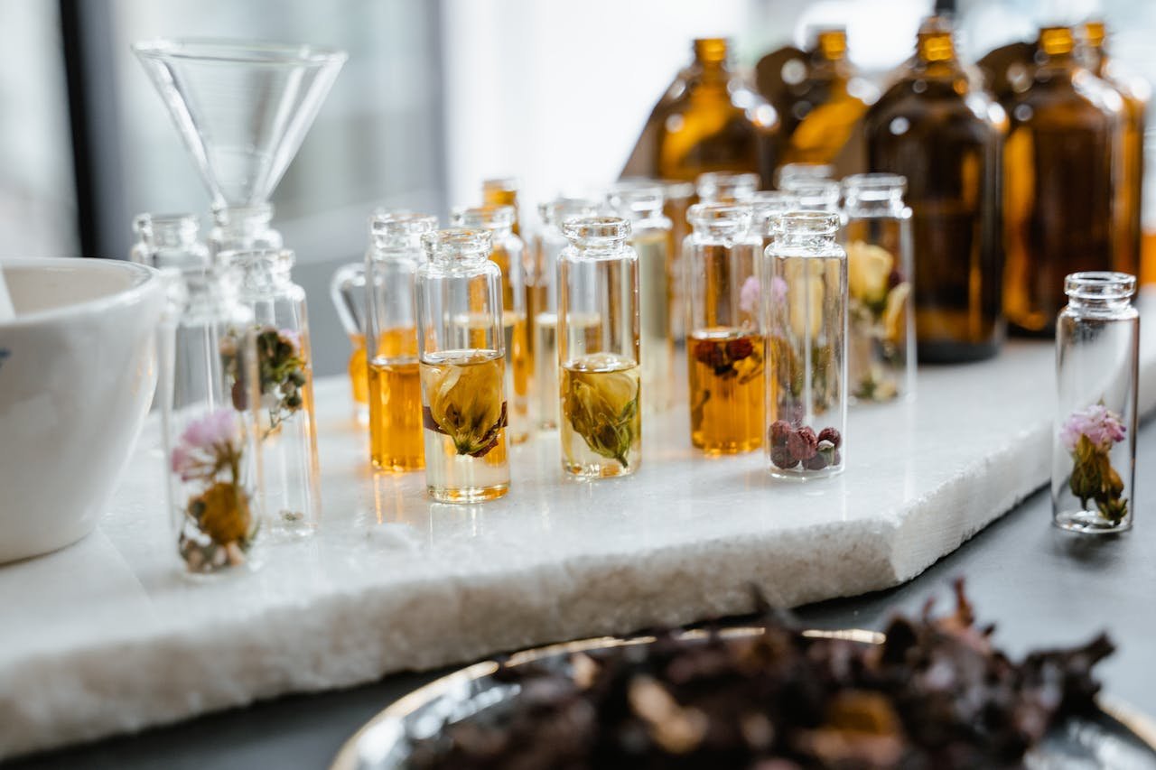 Close-up of various aromatic floral oils in glass bottles, showcasing their vibrant colors and natural ingredients.