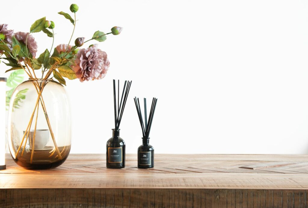Glass diffuser bottle with reeds and flowers at home